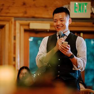 Jerry Zhou 周洁瑞，微笑着拿着话筒